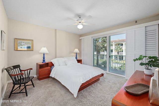 carpeted bedroom with ceiling fan, access to exterior, baseboards, and a textured ceiling