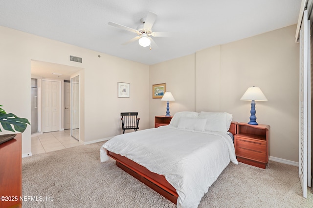 carpeted bedroom with visible vents, baseboards, ceiling fan, and tile patterned flooring