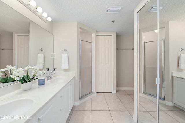 bathroom with a stall shower, visible vents, a closet, and a sink