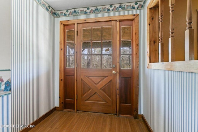 entryway with baseboards and wood finished floors