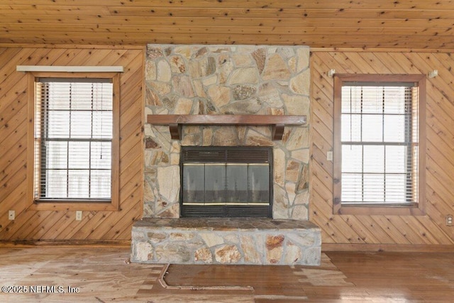 interior details with wood finished floors, wooden walls, and a fireplace