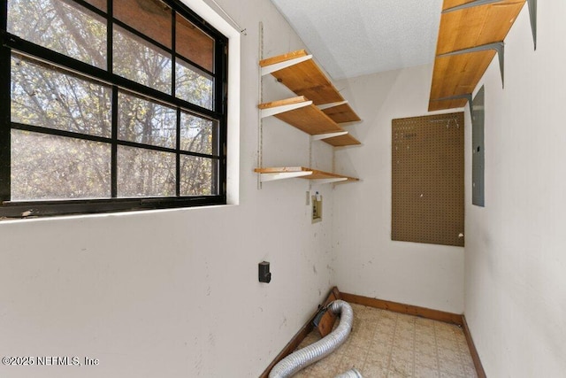 laundry room featuring baseboards, laundry area, washer hookup, a textured ceiling, and tile patterned floors