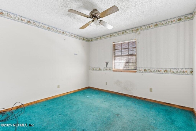 carpeted empty room featuring ceiling fan, baseboards, and a textured ceiling