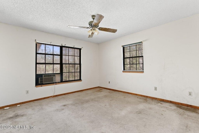 carpeted empty room featuring ceiling fan, baseboards, a wealth of natural light, and a textured ceiling