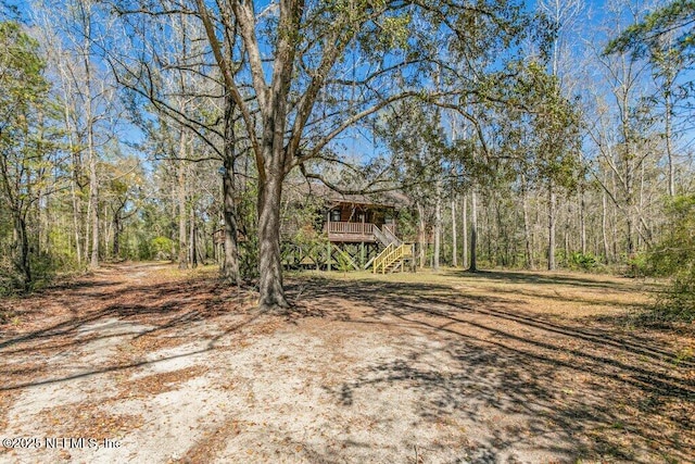 view of yard with a wooded view and stairs