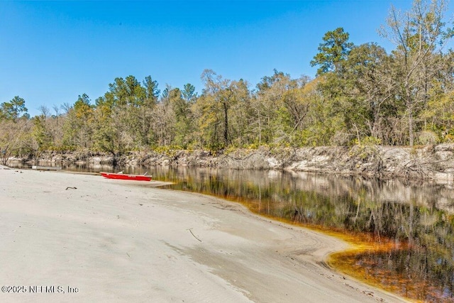 view of road featuring a view of trees and a water view