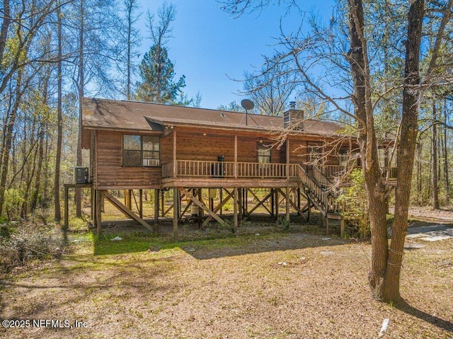 back of house with a chimney, stairs, and a deck