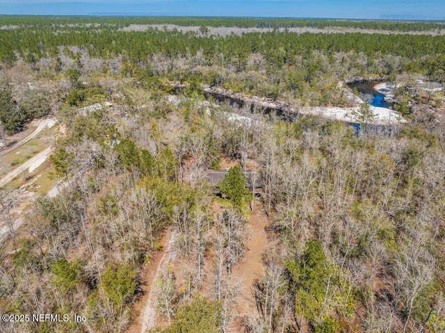 birds eye view of property featuring a view of trees