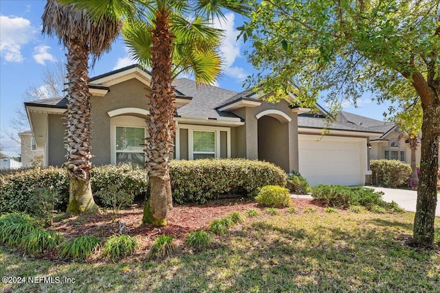 view of front of house with an attached garage, driveway, and stucco siding