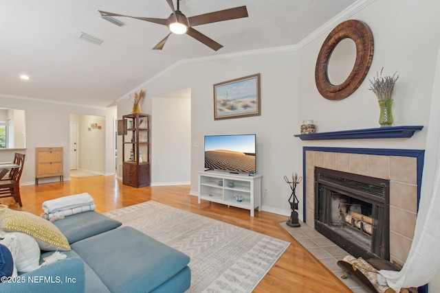 living room featuring a fireplace, a ceiling fan, wood finished floors, and crown molding