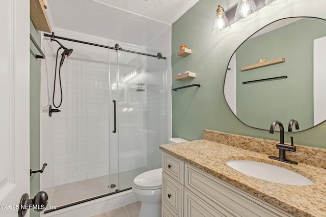 full bathroom with a stall shower, toilet, vanity, and a textured ceiling