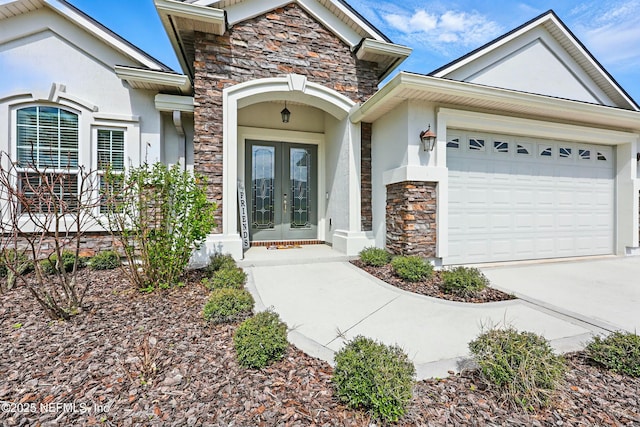 view of exterior entry featuring french doors, stone siding, an attached garage, and stucco siding