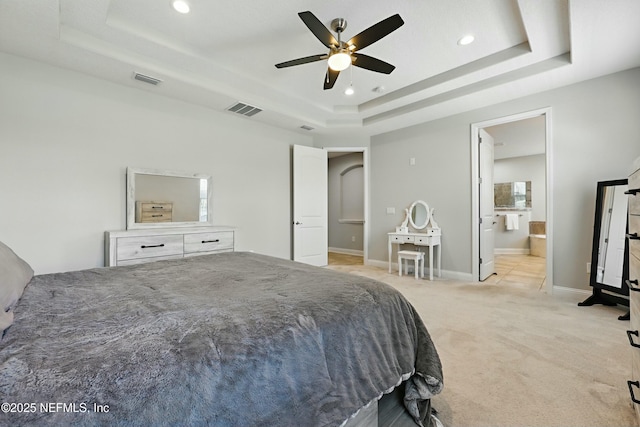 bedroom with baseboards, a tray ceiling, light carpet, and visible vents