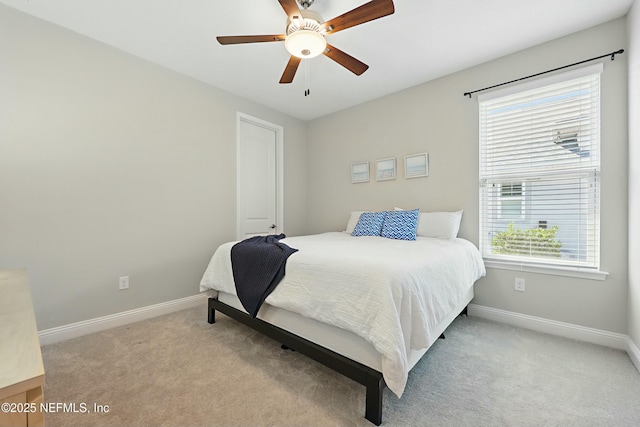 carpeted bedroom featuring baseboards and a ceiling fan