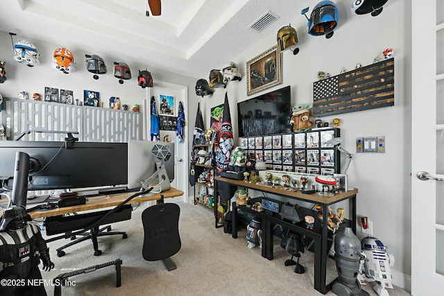 carpeted home office with ceiling fan, visible vents, and a textured ceiling