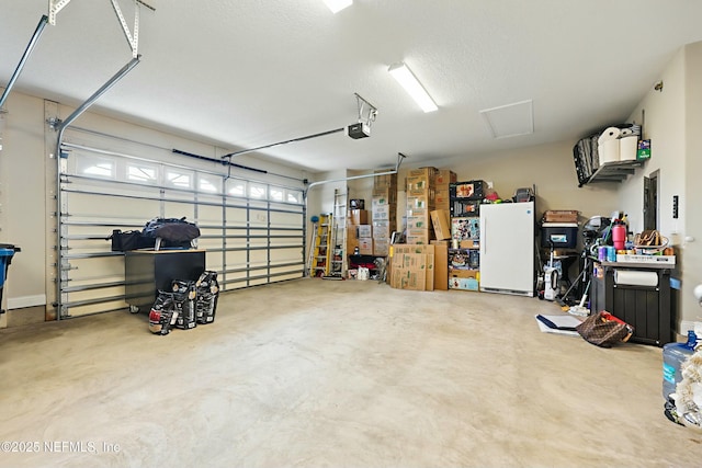 garage featuring freestanding refrigerator and a garage door opener