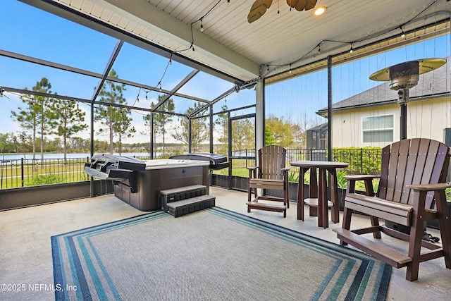 sunroom / solarium featuring ceiling fan and a water view