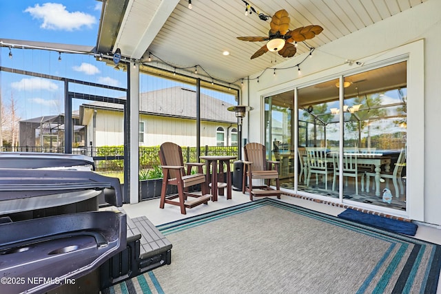 sunroom / solarium with rail lighting, wood ceiling, and ceiling fan