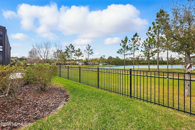 view of yard featuring a water view and fence