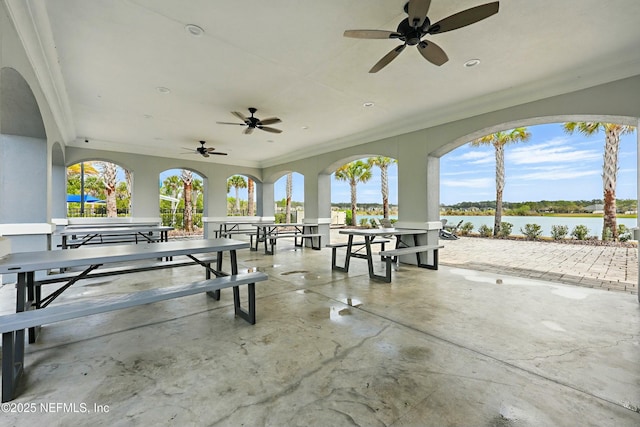 view of patio / terrace with outdoor dining space, a ceiling fan, and a water view