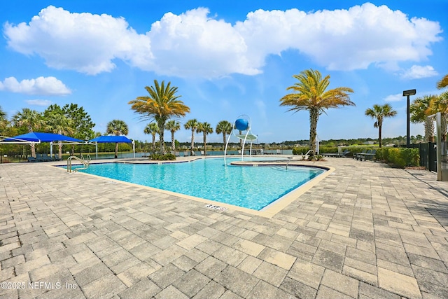 pool with a patio and fence