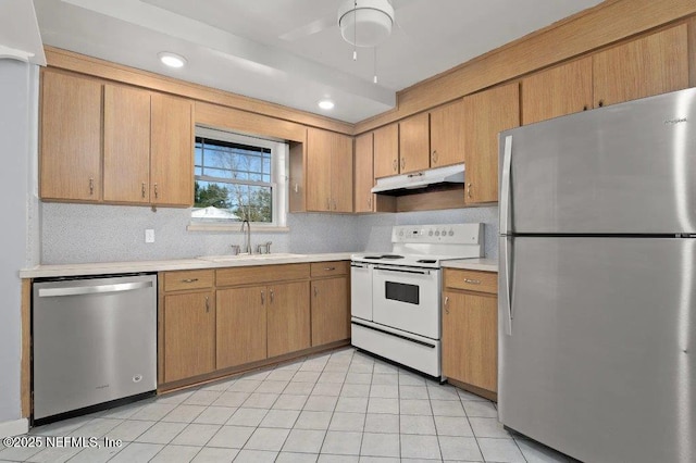 kitchen featuring a sink, decorative backsplash, light countertops, stainless steel appliances, and under cabinet range hood