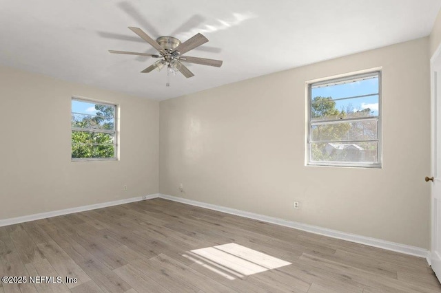 empty room featuring ceiling fan, light wood-type flooring, and baseboards