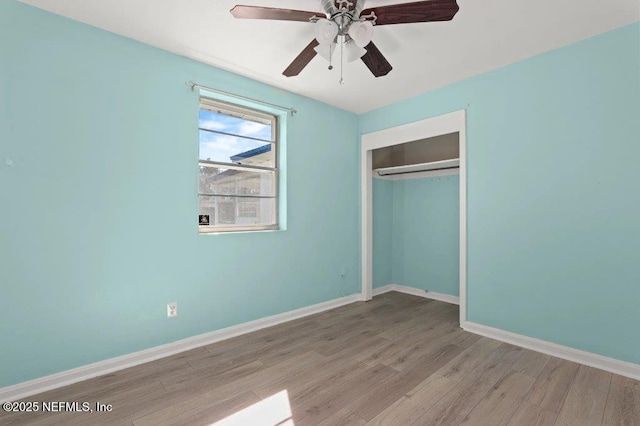 unfurnished bedroom featuring a closet, ceiling fan, baseboards, and wood finished floors