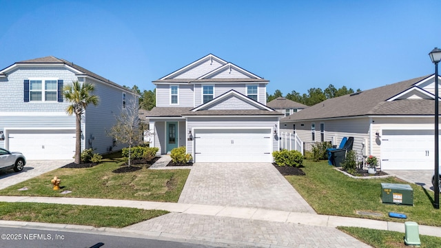 traditional-style home with a garage, decorative driveway, and a front yard