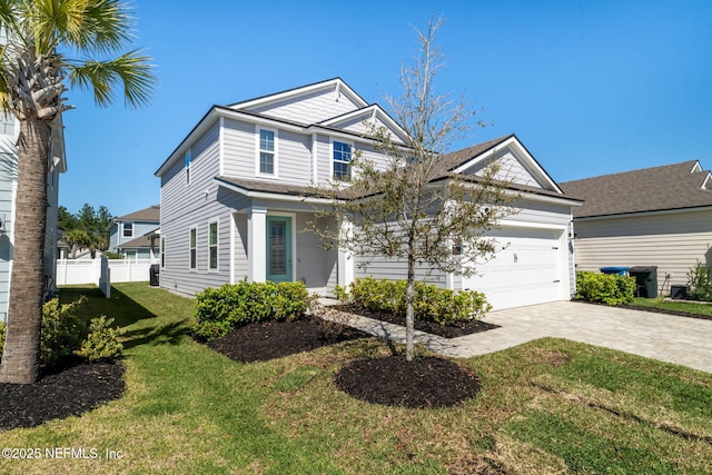 view of front of house featuring decorative driveway, an attached garage, a front yard, and fence