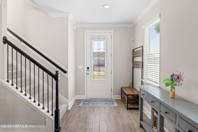 entrance foyer with a wealth of natural light, crown molding, and light wood-type flooring