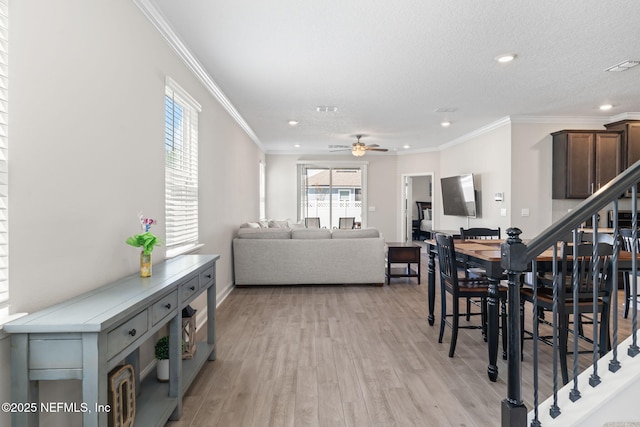 dining space featuring stairway, light wood-style flooring, visible vents, and ornamental molding