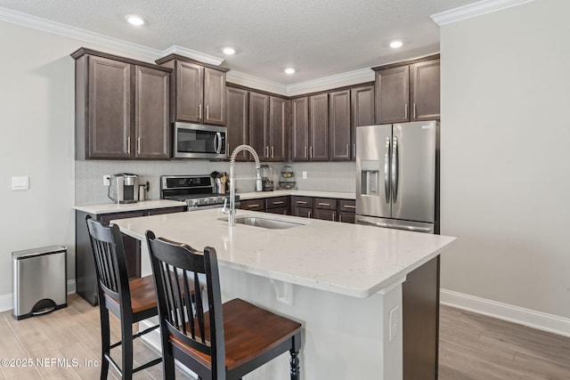 kitchen with a sink, decorative backsplash, dark brown cabinets, and stainless steel appliances