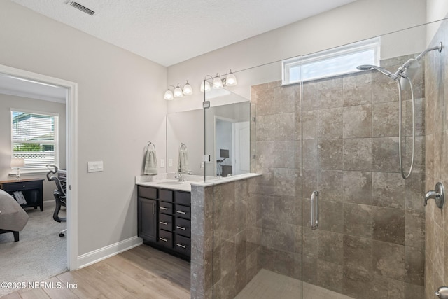 full bathroom featuring visible vents, a stall shower, wood finished floors, baseboards, and vanity