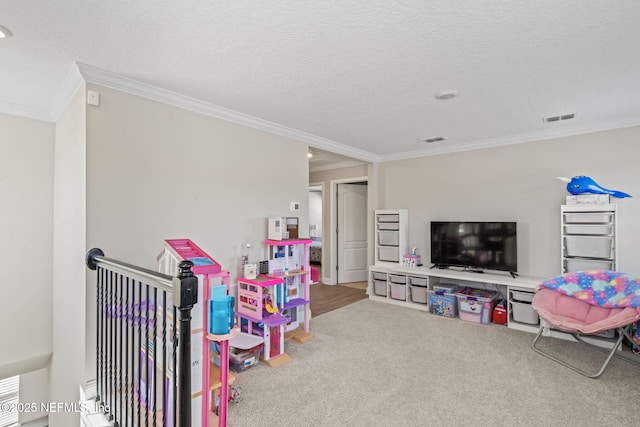 game room featuring ornamental molding, carpet, visible vents, and a textured ceiling