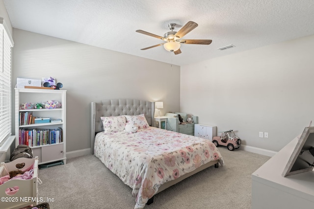 carpeted bedroom featuring visible vents, ceiling fan, a textured ceiling, and baseboards