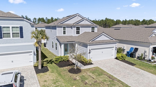 view of front of property with a front lawn, decorative driveway, and roof with shingles