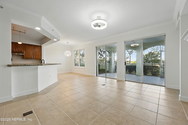 unfurnished living room featuring light tile patterned flooring, baseboards, and ornamental molding