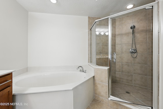 bathroom with a garden tub, a stall shower, and vanity