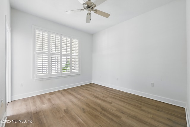 empty room featuring a ceiling fan, wood finished floors, and baseboards