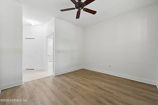 empty room with ceiling fan, baseboards, and wood finished floors