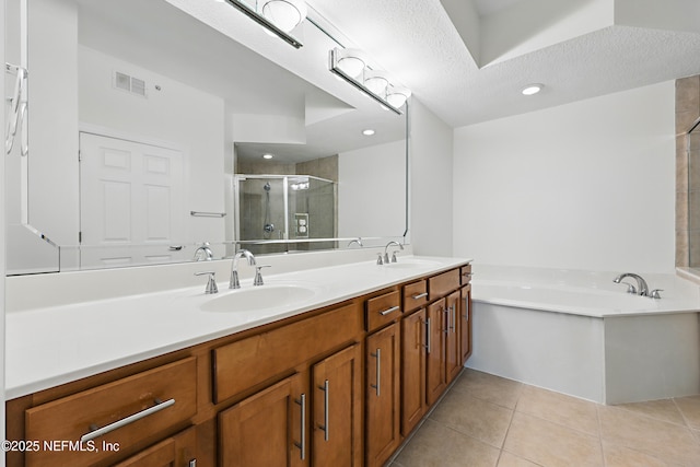 full bathroom with visible vents, a sink, tile patterned flooring, a shower stall, and a textured ceiling