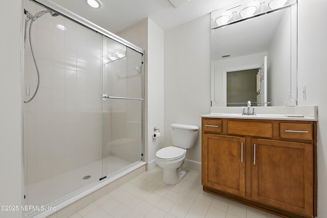 bathroom featuring vanity, baseboards, a shower stall, tile patterned floors, and toilet