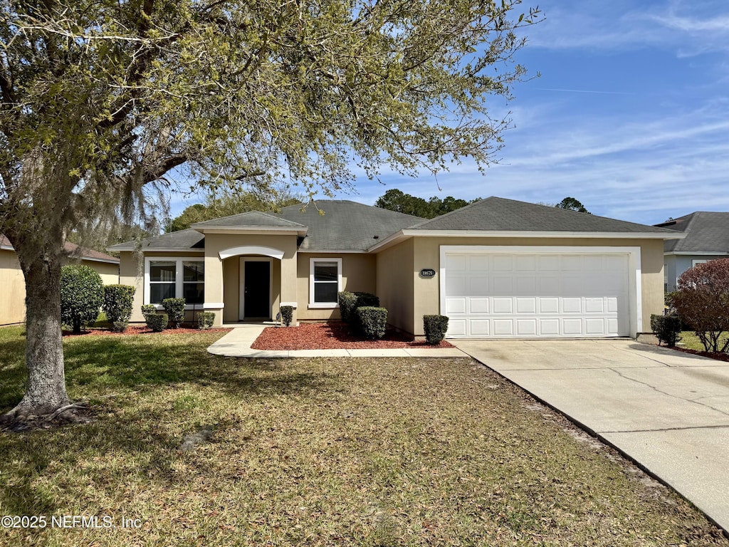 ranch-style house featuring stucco siding, a garage, concrete driveway, and a front lawn