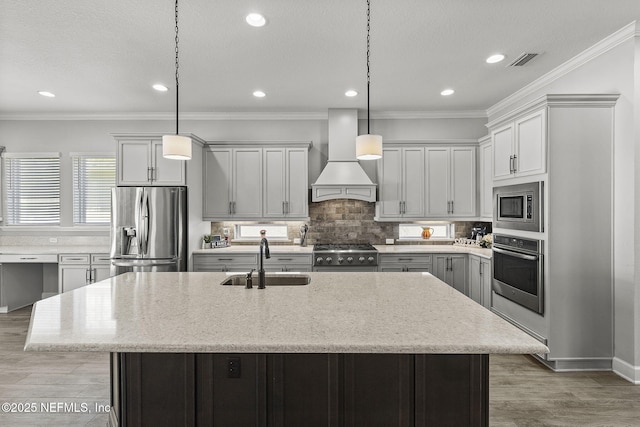 kitchen with visible vents, ornamental molding, appliances with stainless steel finishes, custom exhaust hood, and a sink