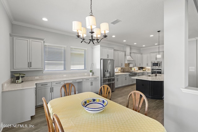 dining area featuring visible vents, dark wood finished floors, recessed lighting, an inviting chandelier, and crown molding