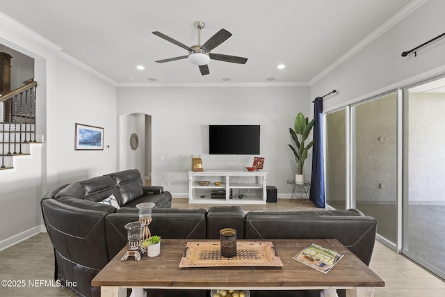 living area featuring light wood-style flooring, baseboards, ceiling fan, and ornamental molding