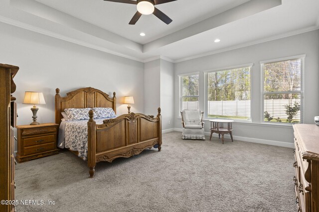 bedroom featuring ornamental molding, baseboards, a tray ceiling, and carpet floors