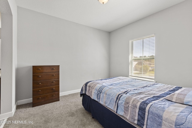 bedroom with baseboards and carpet