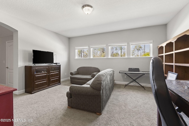 living area featuring plenty of natural light, arched walkways, and carpet floors